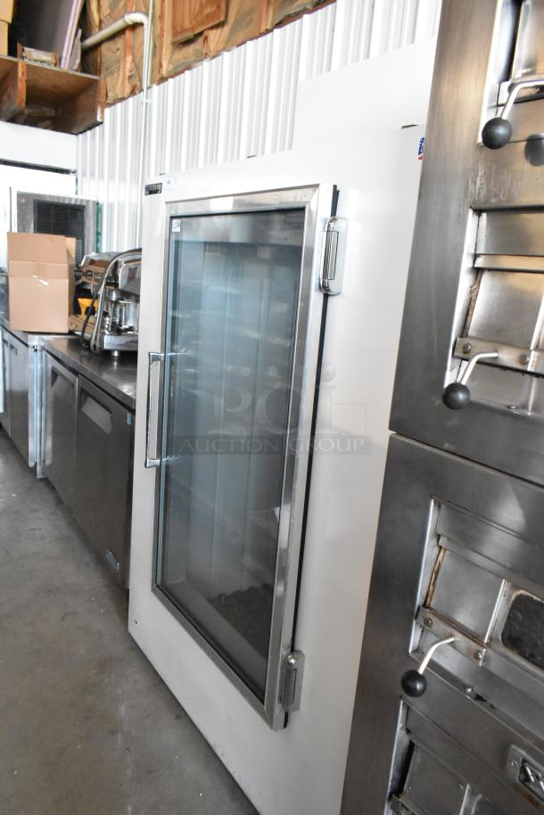 Commercial glass-door refrigerator, white with stainless steel trim, in good condition, suitable for restaurant use.