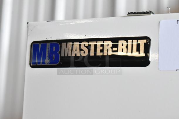Master-Bilt refrigeration unit label, black and gold with logo. Slight wear on the white surface.