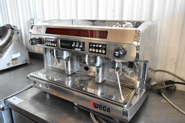 Wega espresso machine, stainless steel, dual group heads, digital controls, in good condition. Model label visible.