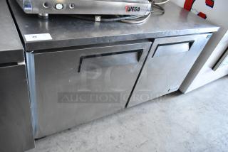 Stainless steel double-door undercounter fridge, minor surface wear, brand label "Wega," auction tag with number 46.