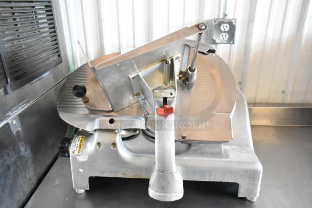 Commercial meat slicer with adjustable blade, stainless steel build, visible wear. Safety warning label attached.