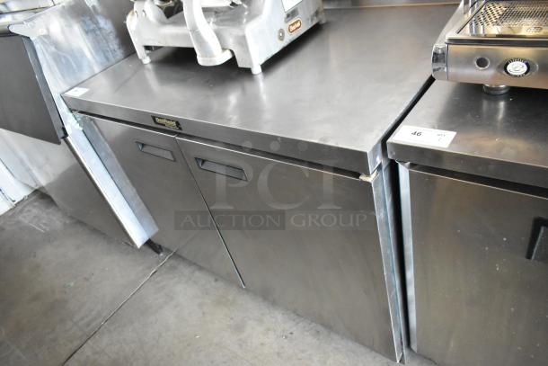 Delfield stainless steel commercial refrigerator with two doors, countertop surface, moderate wear. Auction label number 46 visible.