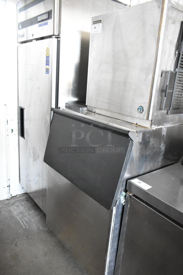 Stainless steel commercial ice machine and freezer set, featuring industrial design with visible controls and panel markings, in good condition.