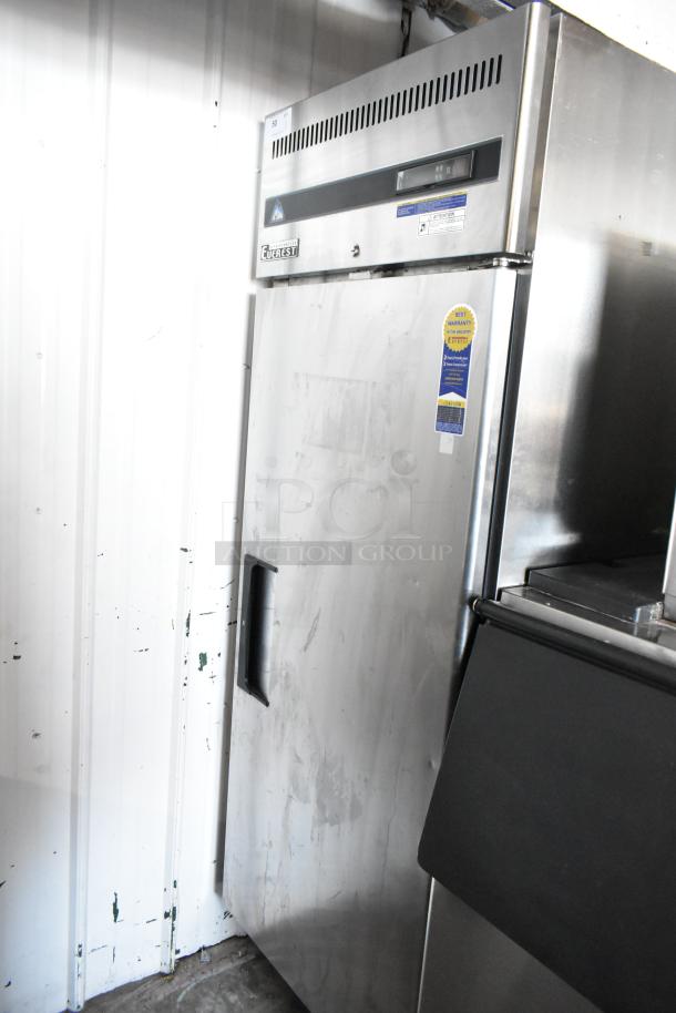 Commercial stainless steel freezer by Everest, single door, digital display, visible wear, warranty sticker on door.