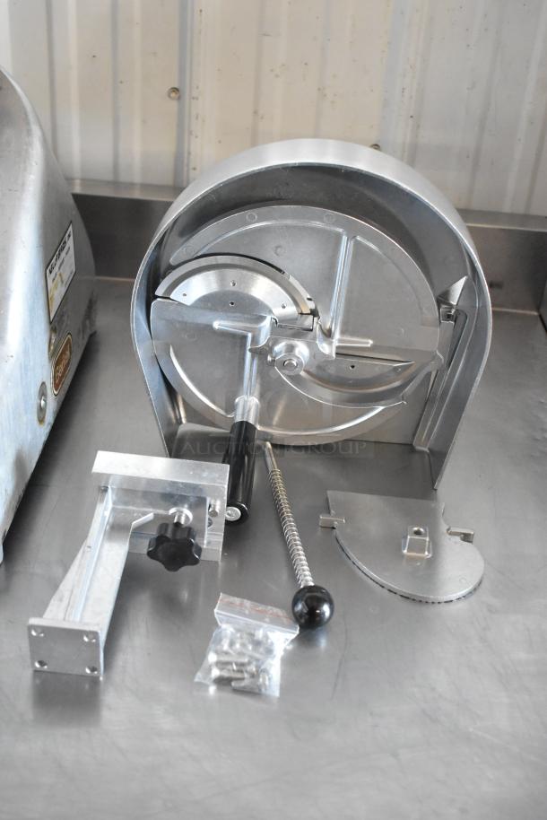 Commercial meat slicer parts in metal, including blade assembly and handle. Includes mounting bracket and screws. Good condition.