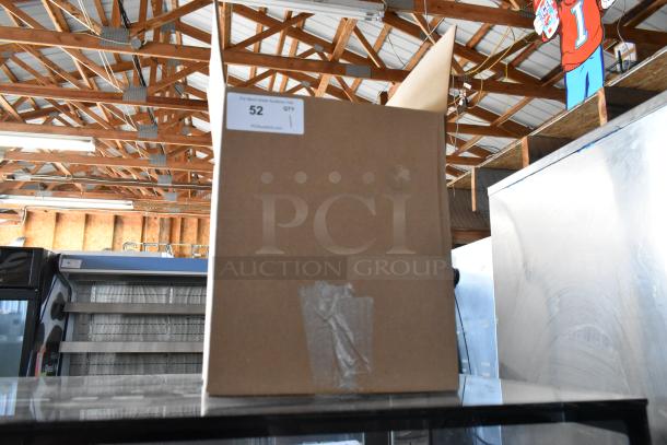 Open cardboard box with visible label showing "52 QTY 1." Box has tape on the side and is placed in a warehouse setting.
