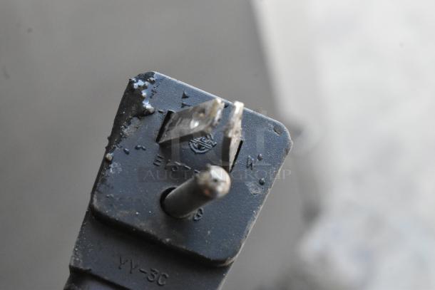 Close-up of a worn electrical plug, marked E157178 and YY-3C, showing signs of corrosion and damage on the prongs.