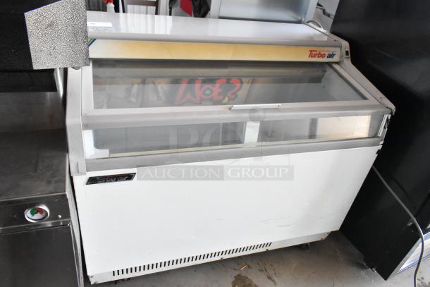 Turbo Air commercial display freezer, white with glass top, used condition, minor scuffs, ideal for retail use.