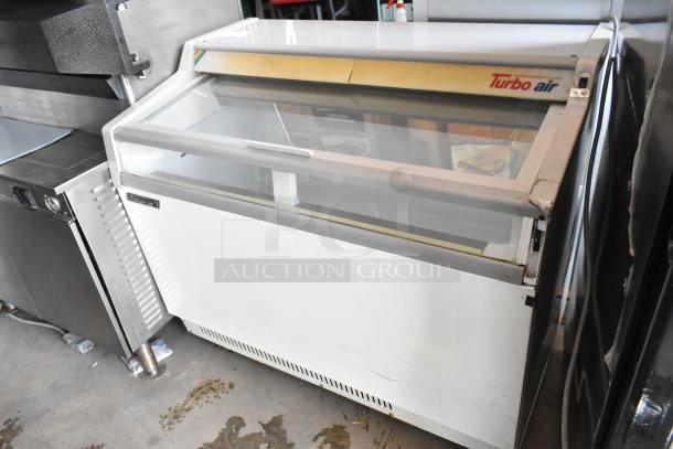 Turbo Air commercial display freezer in used condition with glass sliding door and visible brand label on the top.