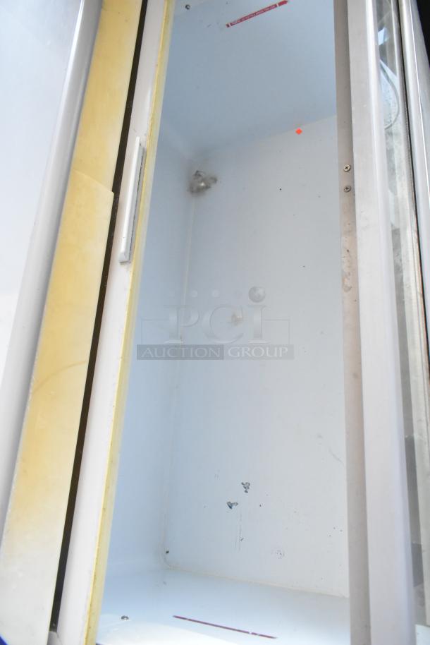 Empty white refrigerator interior with visible dirt and marks. Door seals appear aged. No visible labels or tags.