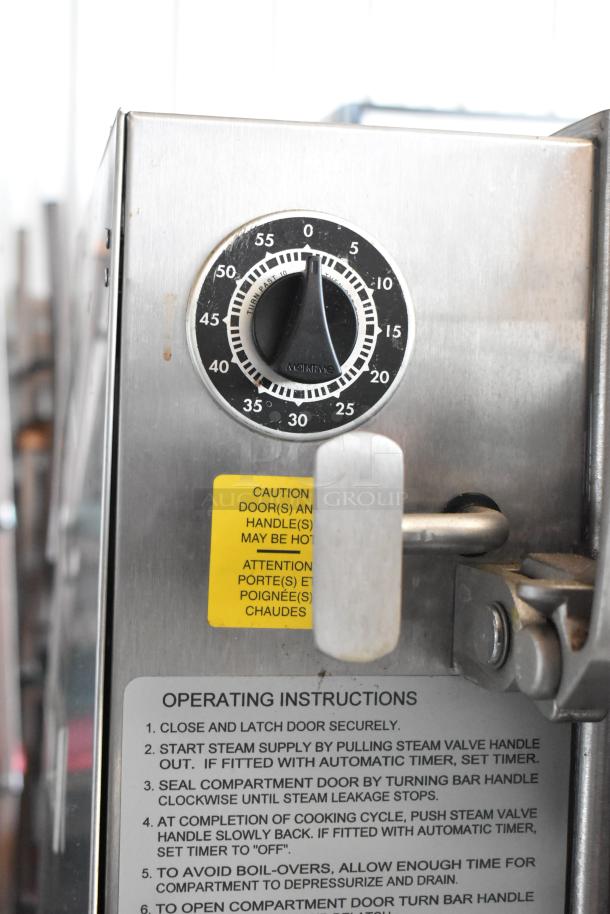 Commercial stainless steel kitchen appliance with a timer dial, handle, caution label, and operating instructions.