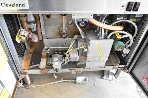 Cleveland commercial kitchen appliance inner workings, showing wiring and pipes, moderate rust, maintenance or repair needed.