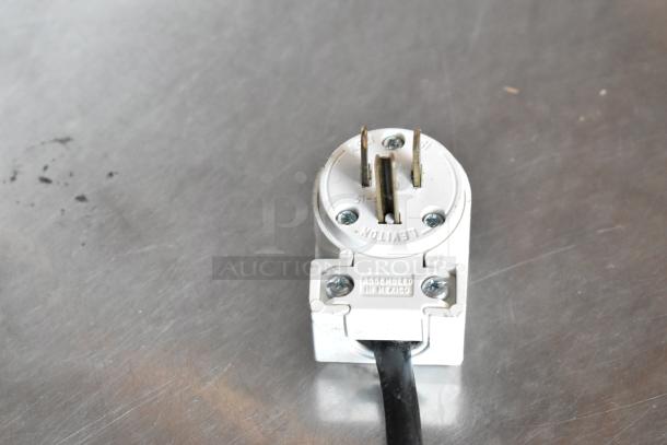 White Leviton electrical plug with visible prongs, labeled "Assembled in Mexico." In good condition.