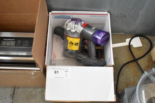 Cordless handheld vacuum cleaner with purple filter, model label visible, in used condition, auction tag number 61.