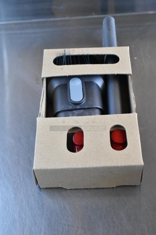 Cardboard box containing brush head and red caps for a vacuum cleaner, in new condition.