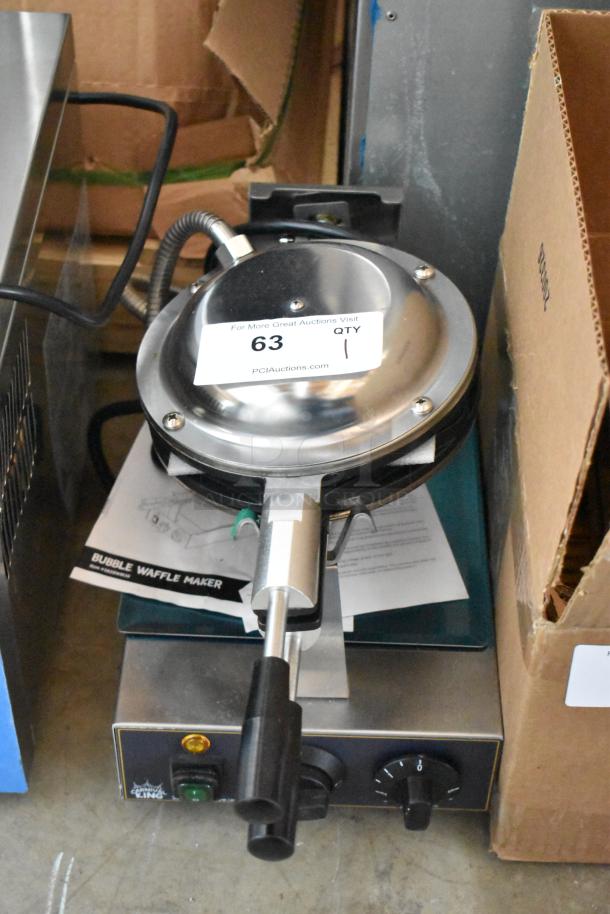 Commercial bubble waffle maker with stainless steel top, control knobs, and black handle. Auction tag with lot number 63.