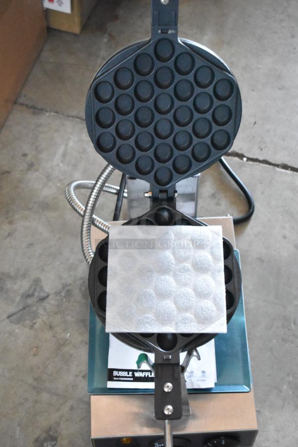 Bubble waffle maker with non-stick coating, stainless steel base, and clear control panel. Includes instruction manual.
