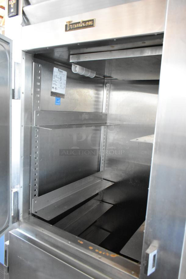 Traulsen stainless steel commercial refrigerator, interior view, adjustable shelves, label indicating model details, used condition.