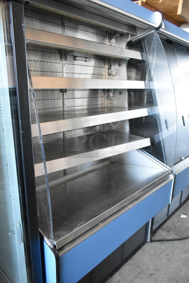 Commercial refrigerated display case with four stainless steel shelves, curved glass front. Good condition, no visible markings.