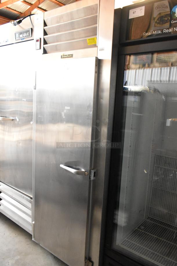 Stainless steel industrial refrigerator, model Traulsen, with digital temperature controls and ventilation grill. Good condition.