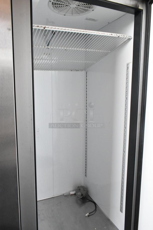 Commercial refrigerator interior with wire shelf and fan, stainless steel finish, clean condition, suitable for restaurant use.