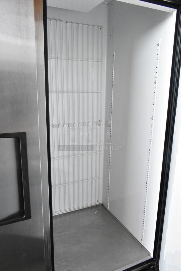 Commercial stainless steel refrigerator interior, empty with wire shelving and adjustable slots. Clean condition.