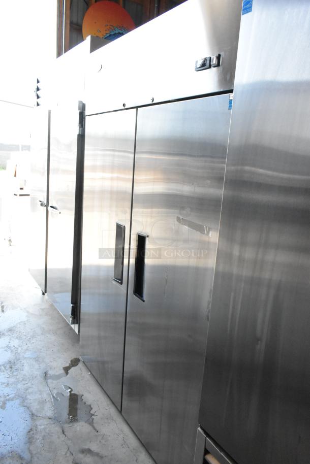 Stainless steel commercial refrigerator with double doors, used condition, slight surface wear, no visible brand or model markings.