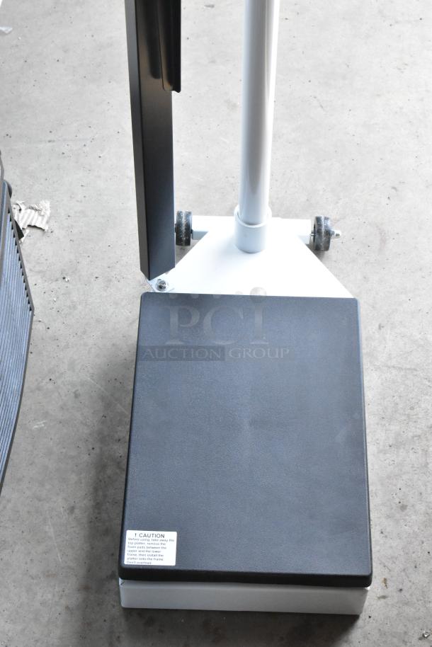 Heavy-duty industrial scale on wheels with black platform and caution label. Excellent condition, ideal for warehouse use.