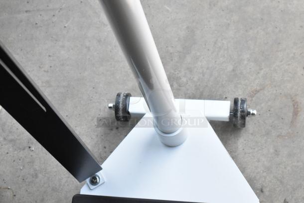 White metal stand with wheels and a triangular base, showing light wear. Ideal for supporting equipment.