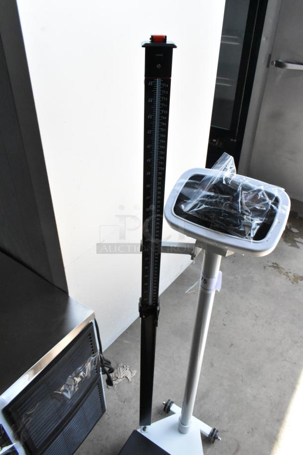 Medical height measuring stand with digital display, black and white, new condition, plastic wrap on base.
