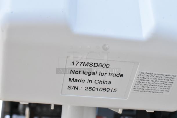 White device with label "177MSD600, Not legal for trade, Made in China, S/N: 250106915," compliance with FCC rules.