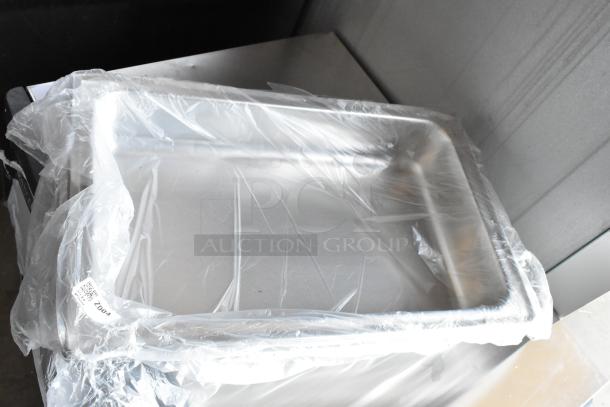 Stainless steel tray wrapped in plastic. Appears new, with a visible tag marked "2004". Suitable for catering use.