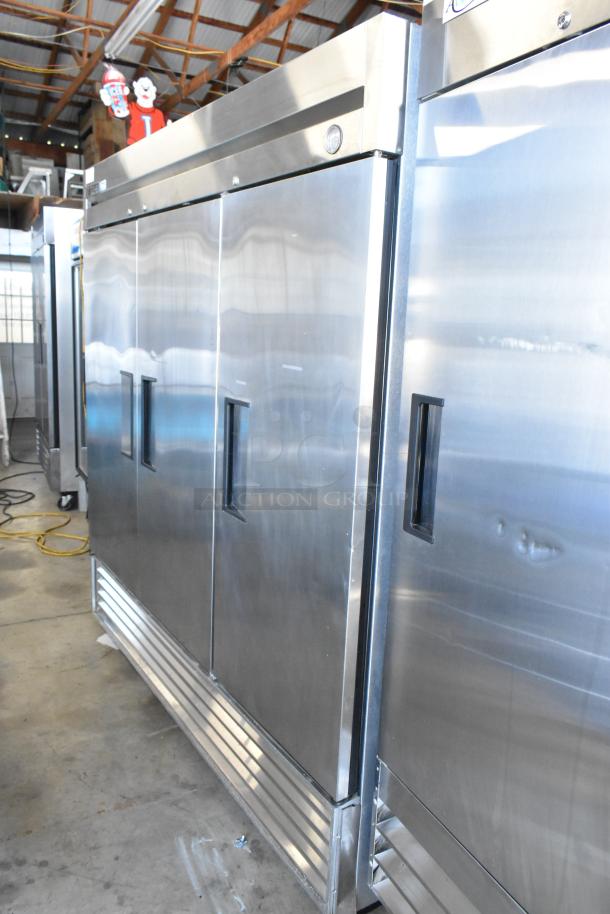 Commercial stainless steel refrigerator, three-door, industrial use, visible thermometer, good condition, minor wear.