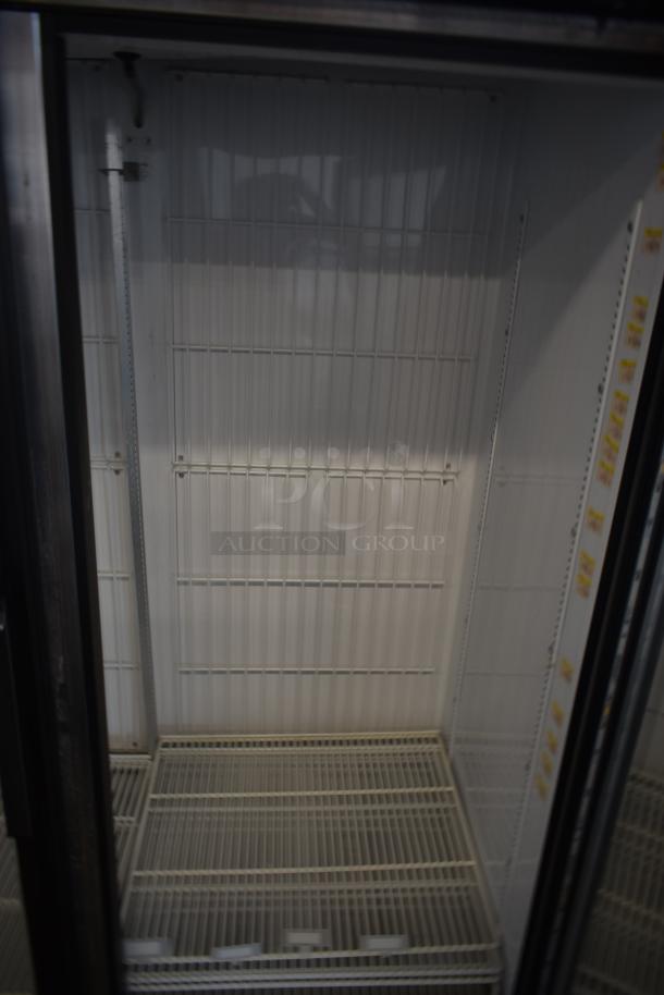 Commercial glass door refrigerator interior, empty wire shelves. White interior panels. In excellent condition.