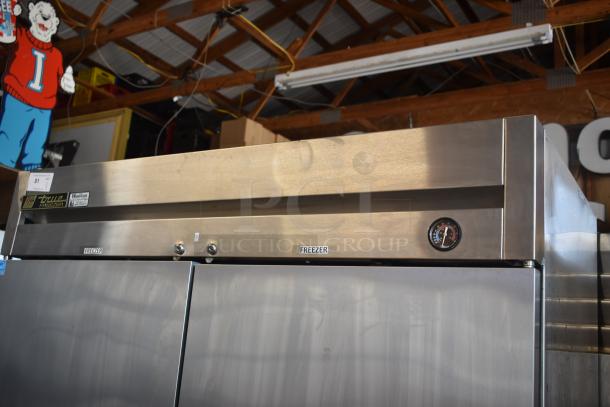 True two-door stainless steel commercial freezer with temperature gauge, "Freezer" label, and model tag, in good condition.