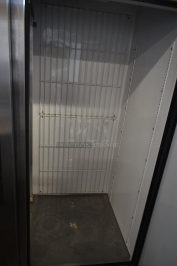 Empty commercial refrigerator interior with metal shelves, stainless steel exterior. Clean condition, no visible markings.