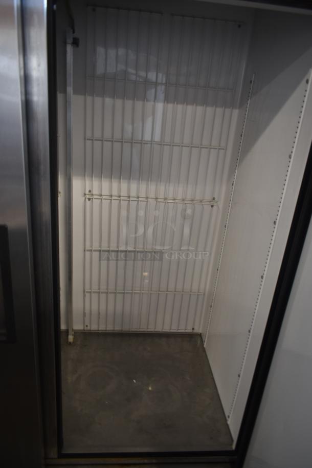 Empty commercial refrigerator interior, featuring wire shelves and stainless steel finish. Good condition, no visible markings.