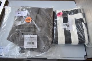 Two Lancaster canopy covers; one gray, one black and white striped. New in packaging, labels with specs and codes visible.