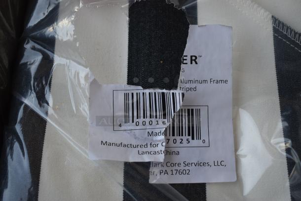 Close-up of a plastic-wrapped item with a torn label showing partial text and barcode. Black and white striped fabric visible.
