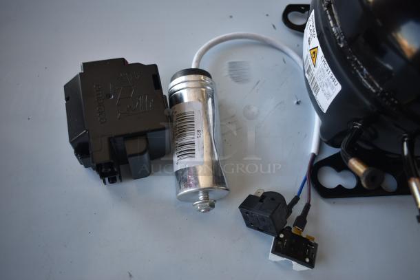 Refrigeration compressor assembly with Embraco relay, capacitor with barcode, and wiring; condition appears new.