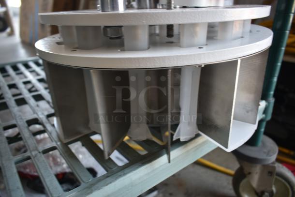 Industrial metal fan component with blades, silver and white finish, mounted on a wheeled platform, in good condition.