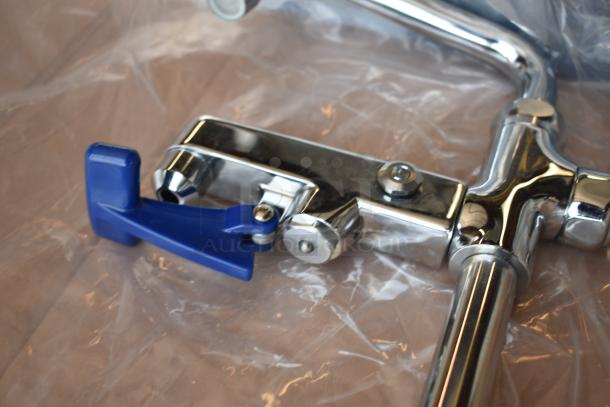 Chrome metal faucet with blue handle, new condition, wrapped in plastic. Ideal for kitchen or bathroom installation.