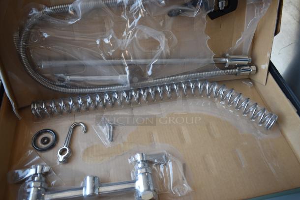 Box of stainless steel faucet components, including flexible hoses and coil, in new condition.