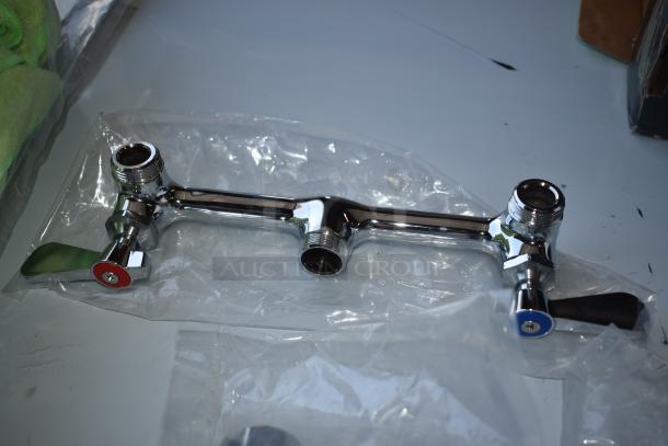 Chrome dual-lever faucet, red and blue handles, new condition, wrapped in clear plastic, ideal for bathroom or kitchen.