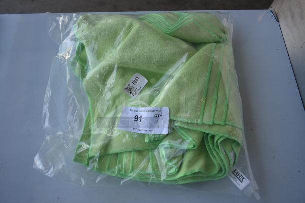 Pack of green microfiber towels in a sealed plastic bag. Tag reads "T047" and "91 QTY 1". Brand: Lavex.