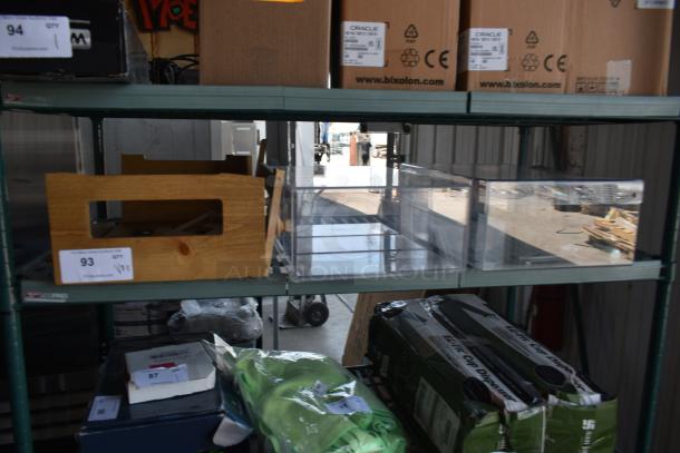 Wooden crate with item label "93 QTY VP1", clear acrylic bin, and cardboard boxes labeled "Oracle" on metal shelving in warehouse.