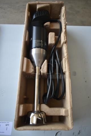 Stainless steel hand blender in protective packaging. Black handle, cord included, appears new with control label visible.