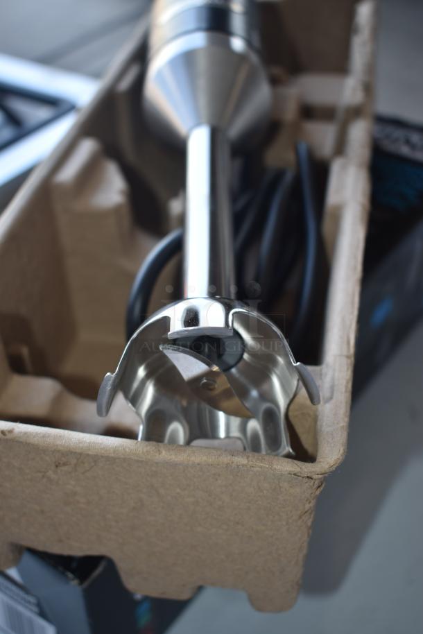 Stainless steel immersion blender with protective blade guard, new condition, in original packaging.