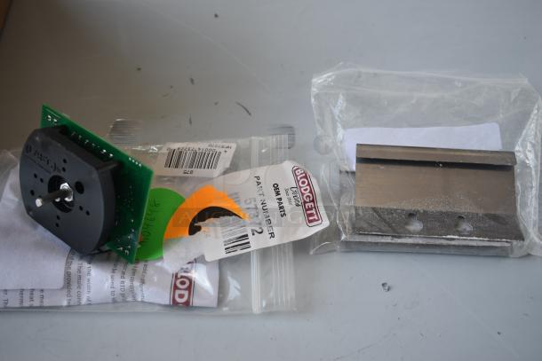 Blodgett OEM parts, including a circuit board and metal component, in bags. Tags show part numbers and barcodes.