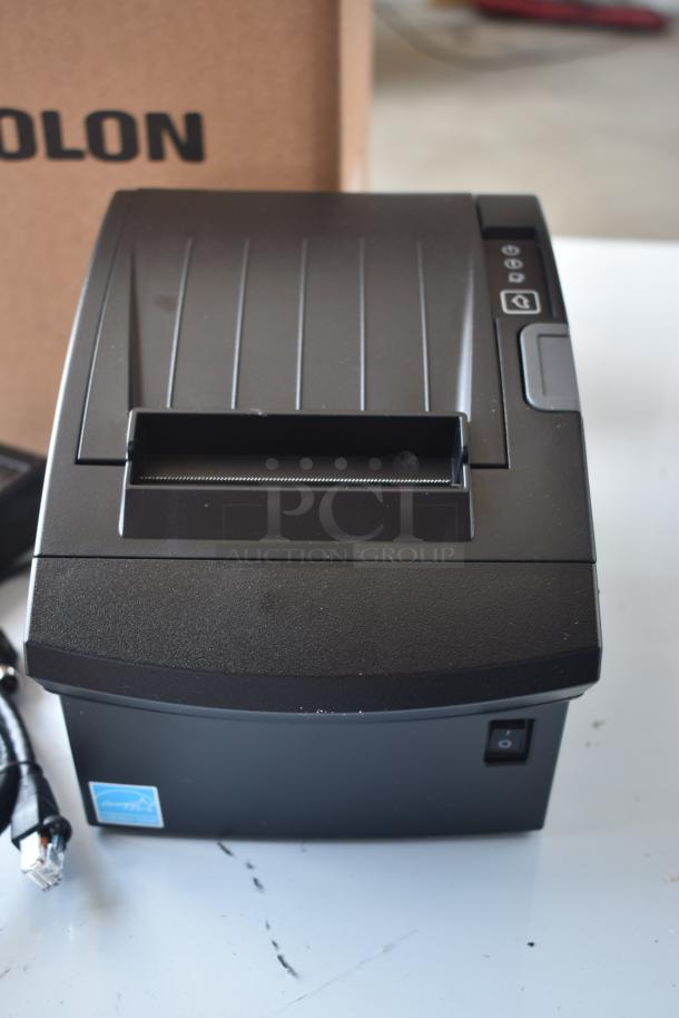 Thermal receipt printer, black, new condition, front control panel with power button. Blue label with "Epson" visible.